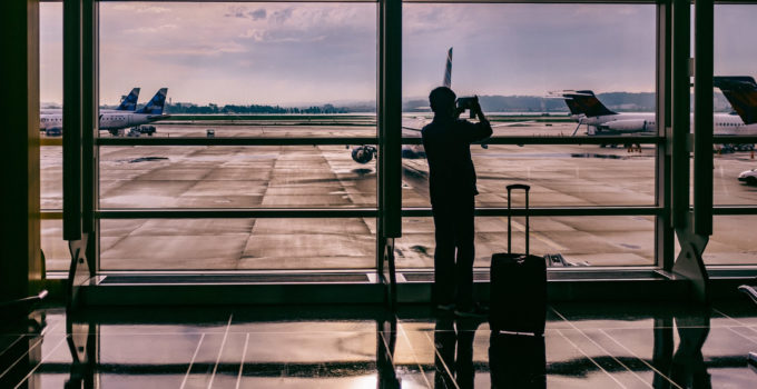 Homem em aeroporto, pronto para viajar de avião